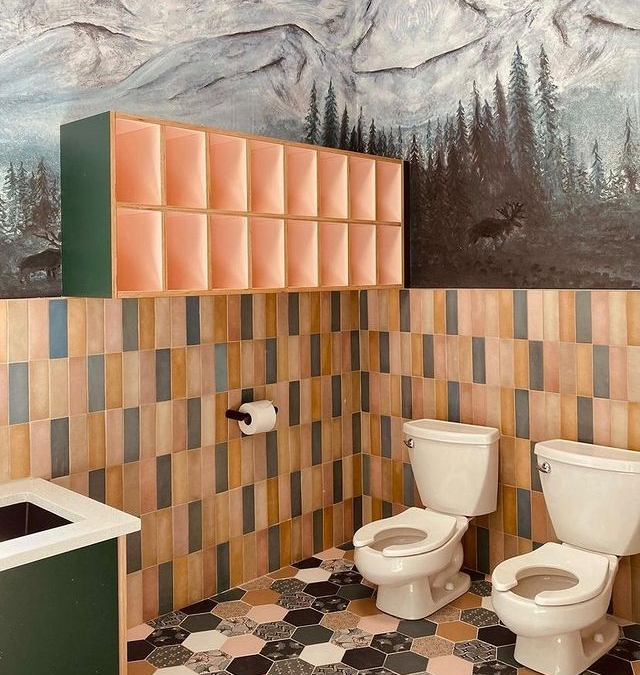 bathroom with yellow and blue tile and a landscape painting of trees on the wall